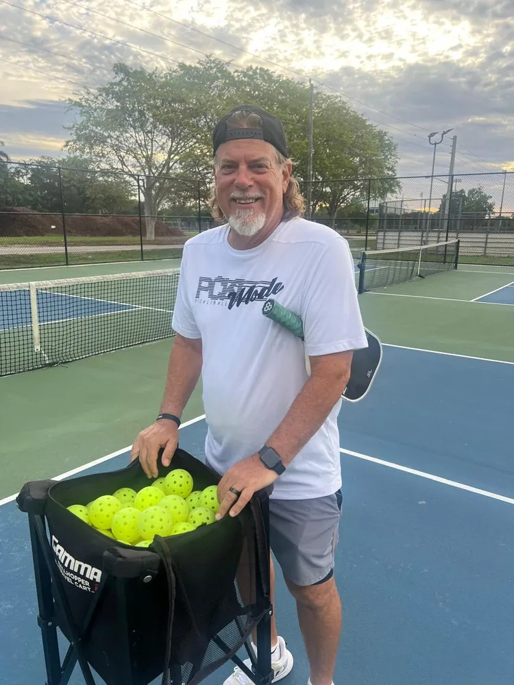 Coach Pillo — Dink Club resident pickleball coach, with a ball cart on the courts in Miami