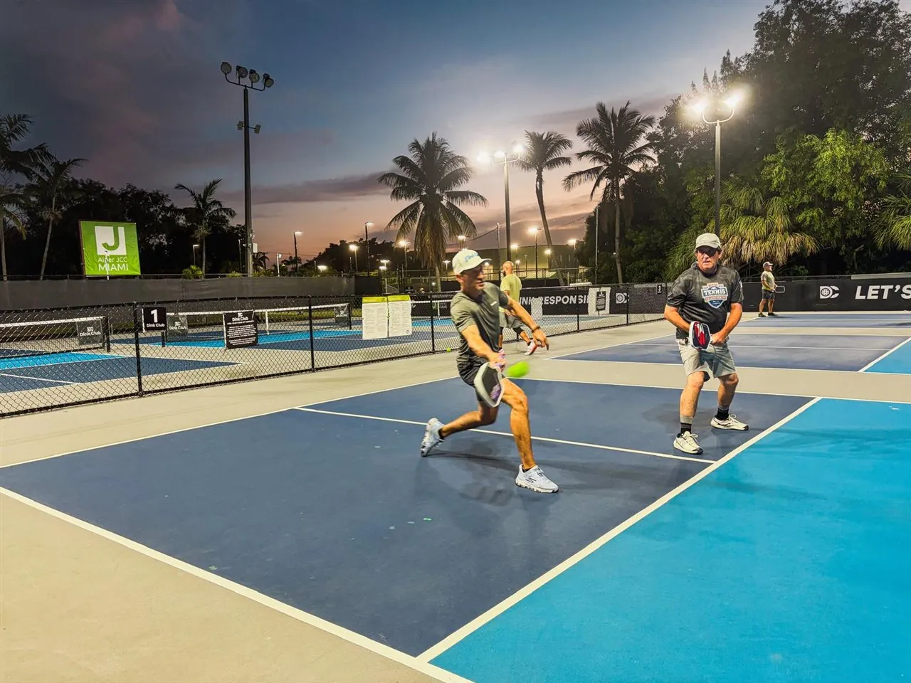 Dink Club players rallying at sunset on the outdoor courts in Miami