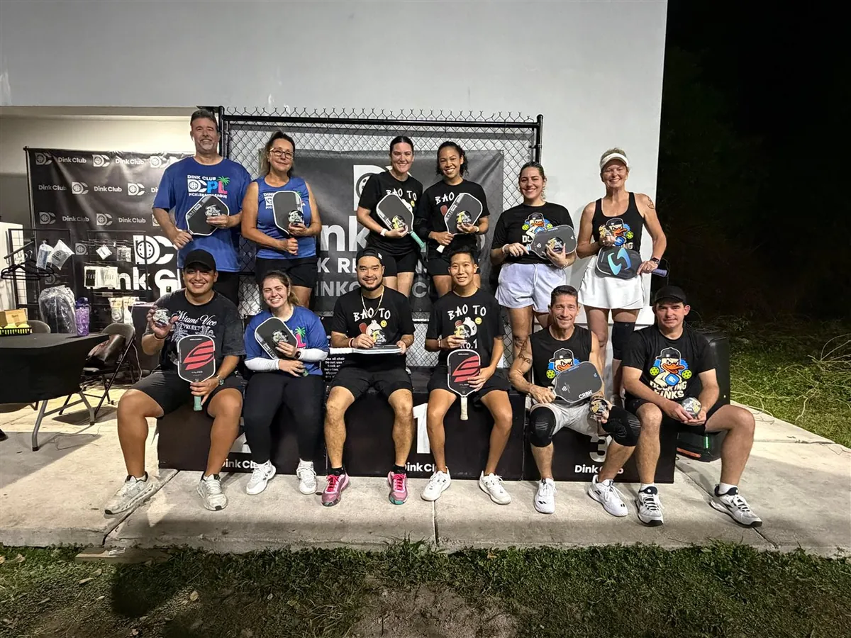 An open play pickleball crew together on the outdoor courts at Dink Club in Miami
